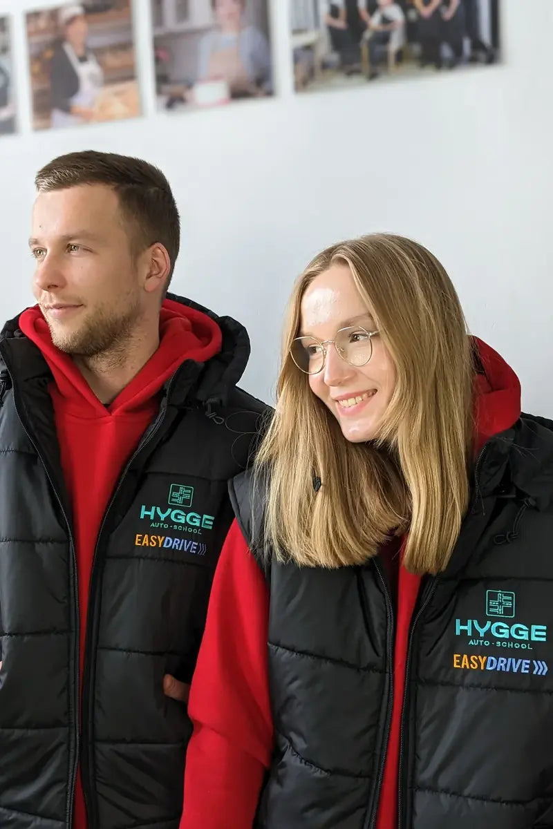 Company staff wearing black work vests with embroidered logos