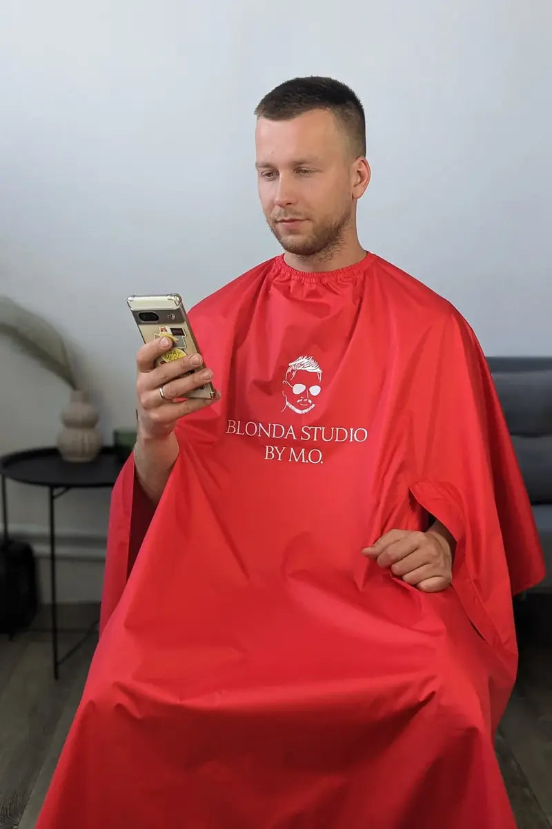 Client wearing a red VSETEX hairdresser and barber cape