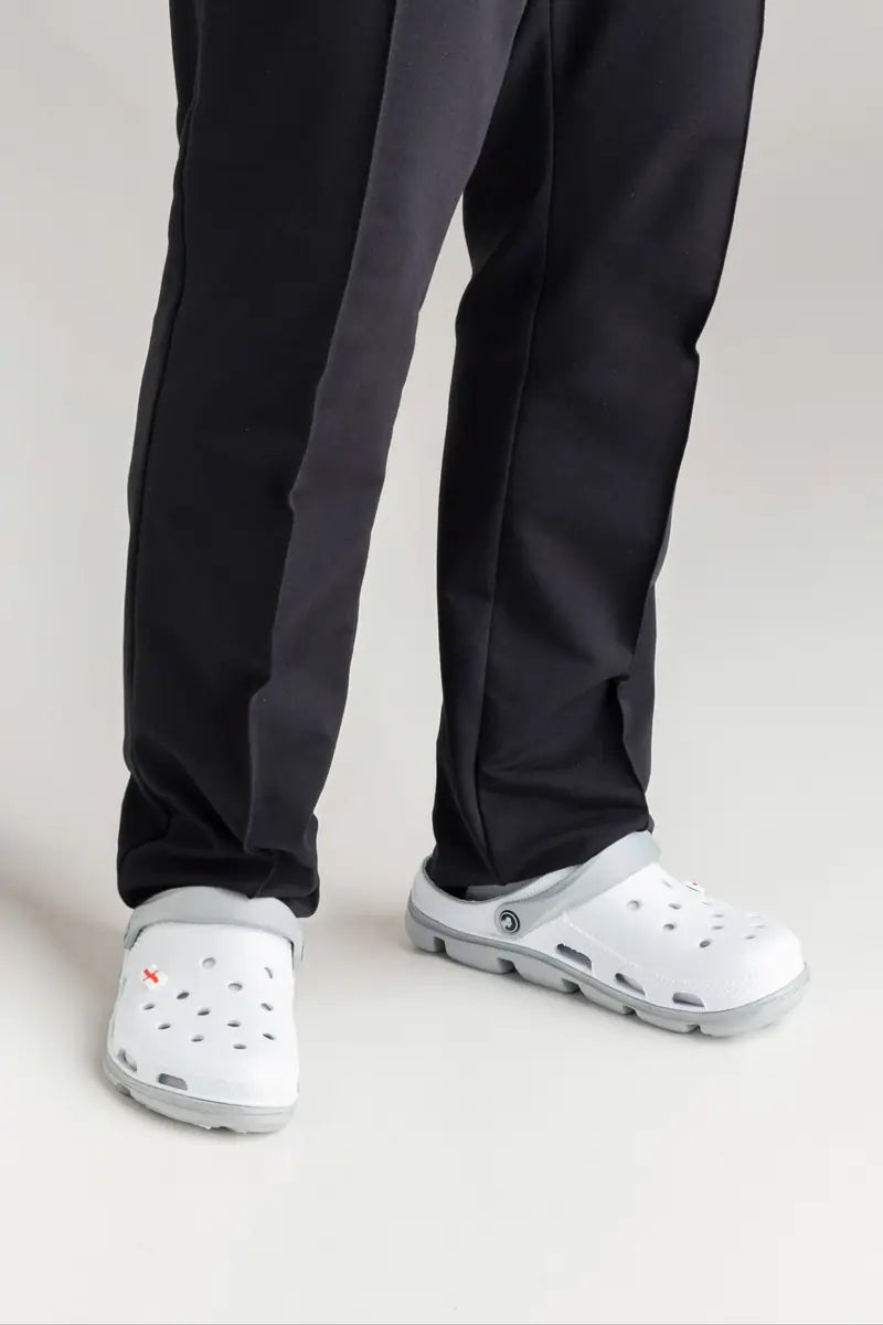 White professional work clogs worn with black staff trousers