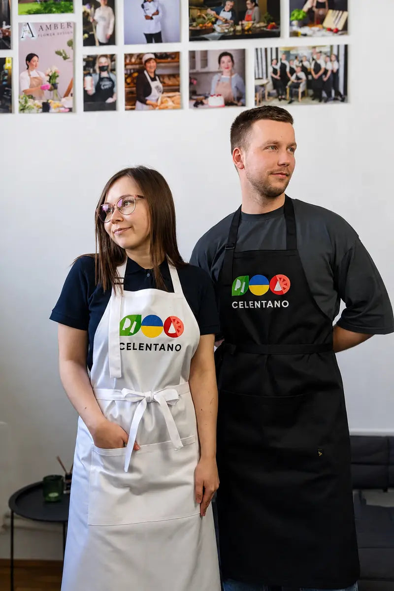 restaurant staff members wearing black and white aprons embroidered with the logo