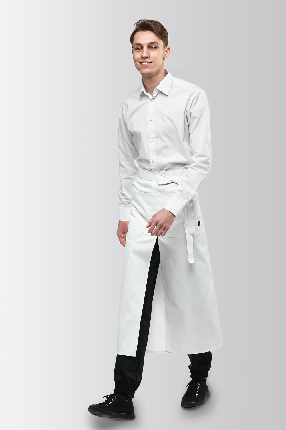 White long bistro apron worn by a male model, three-quarter front view
