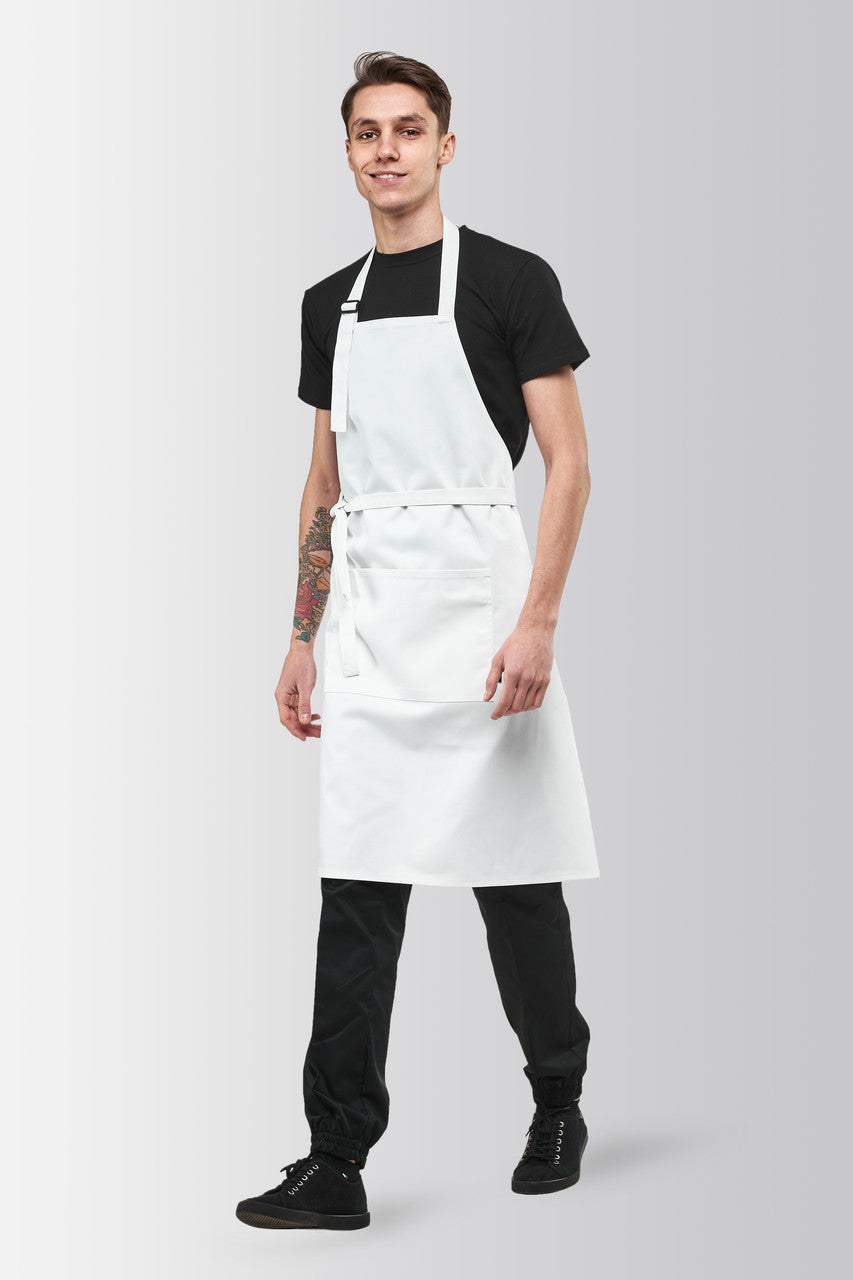 A person wearing a white long apron with an adjustable neck strap and a front pocket, standing against a plain background.