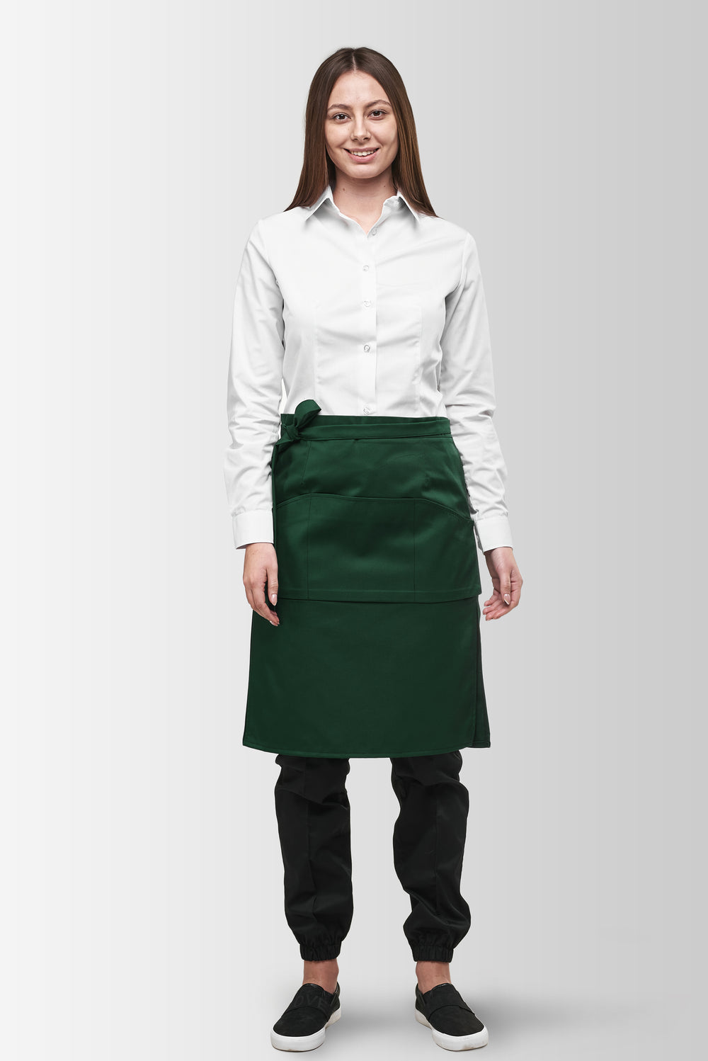 Green Tiramisu waist apron worn by a female model, front view