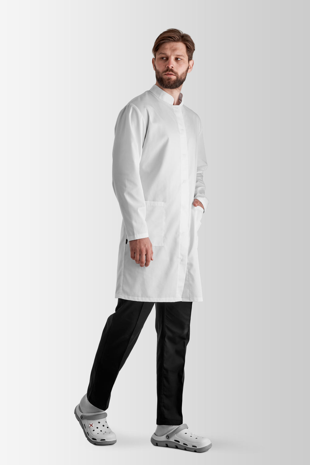 A man wearing a white medical gown with long sleeves, a stand-up collar, and a decorative belt.