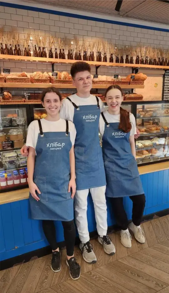 Bakery team wearing custom blue aprons with embroidered company logo