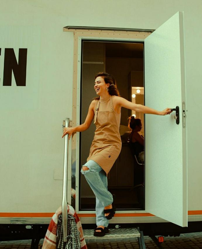 Woman wearing a beige bib apron while leaving a creative studio