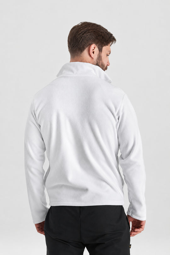 A man viewed from the back wearing a plain white long-sleeve quarter-zip fleece or pullover, paired with black pants, against a light gray studio background.