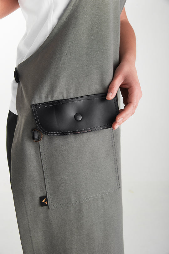 Gray bib apron with black flap pocket and metal snap closure