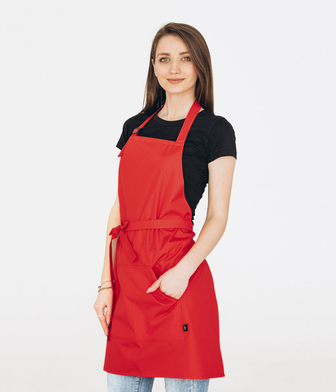 Woman wearing a red bib apron with adjustable neck strap and large front pocket