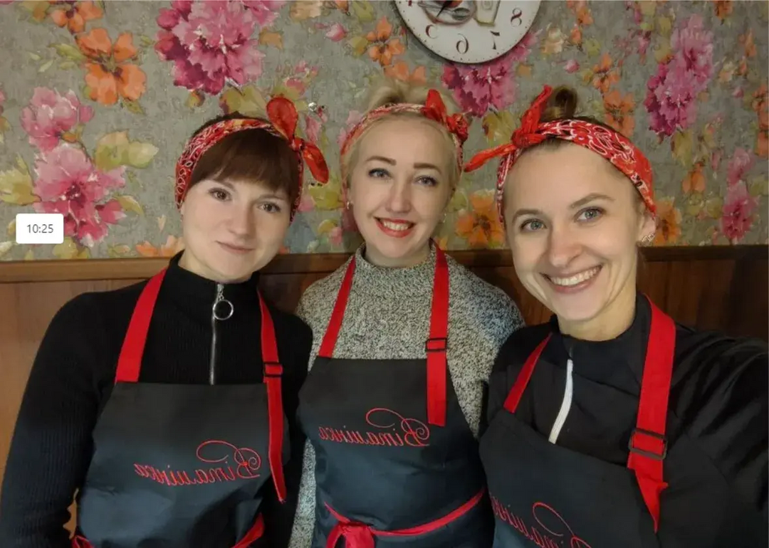 Restaurant team wearing black aprons with red straps and matching headbands