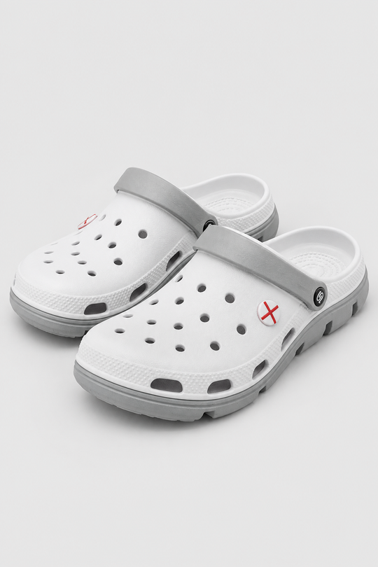 A pair of white and gray clog-style sandals with small red cross logos on the side, displayed on a light gray background.
