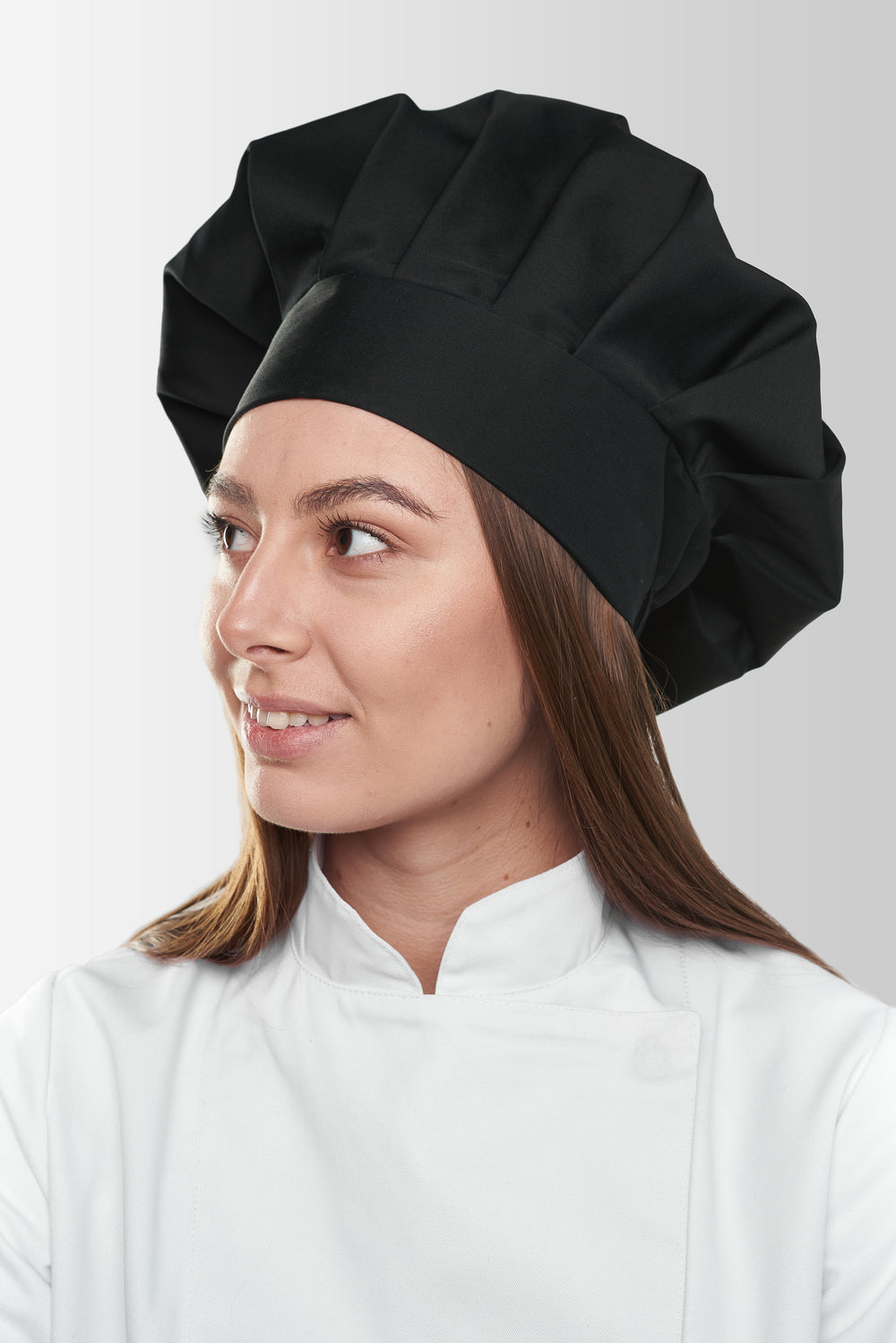 Black chef toque hat worn by a woman, side view